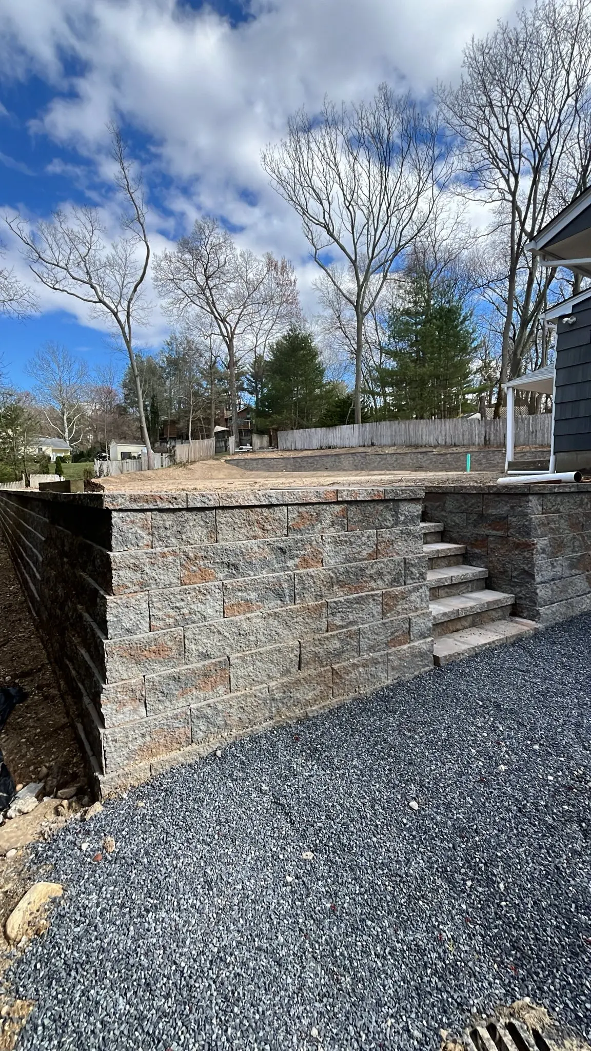 Tiered stone retaining wall with integrated steps built by Marcello Petulla Contracting