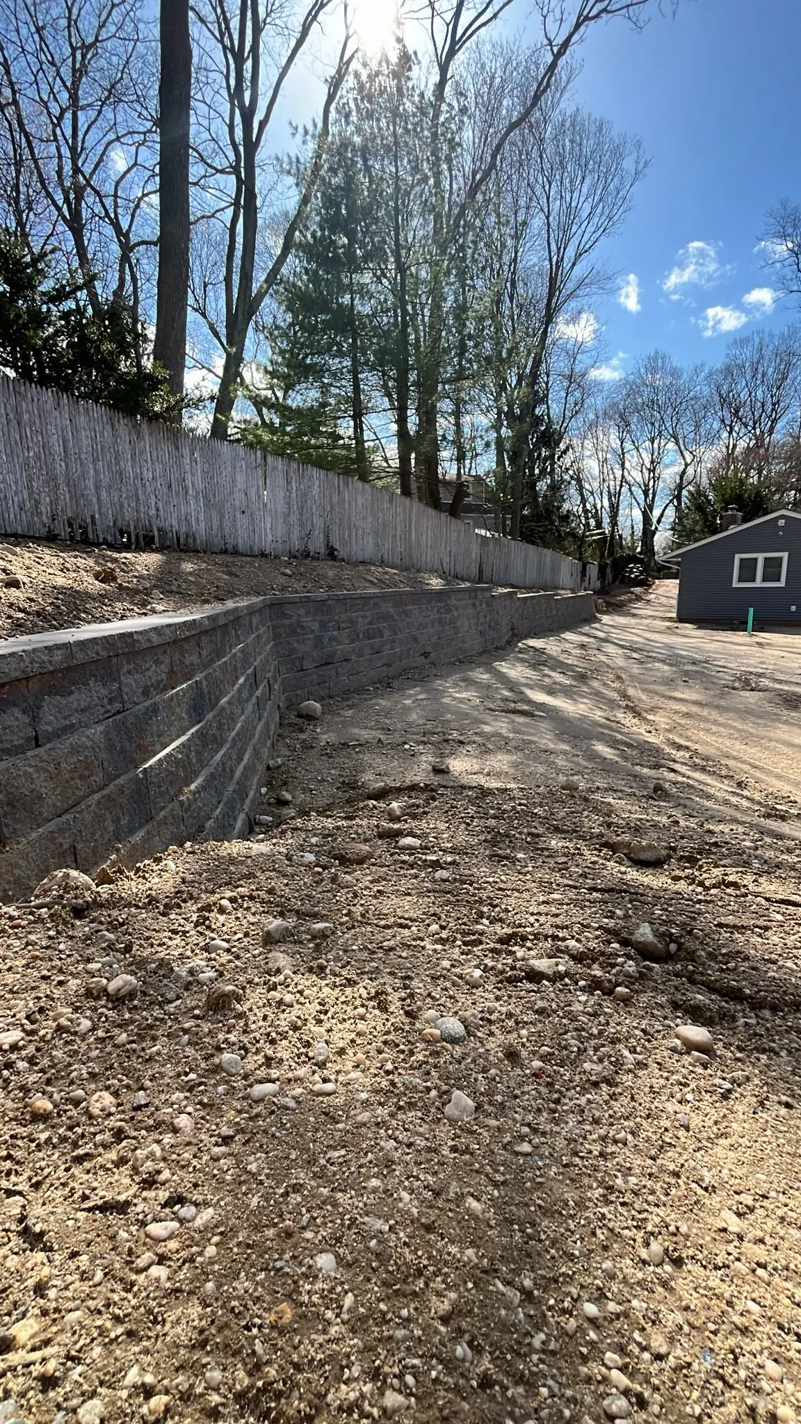 Long segmental block retaining wall running along a sloped property line