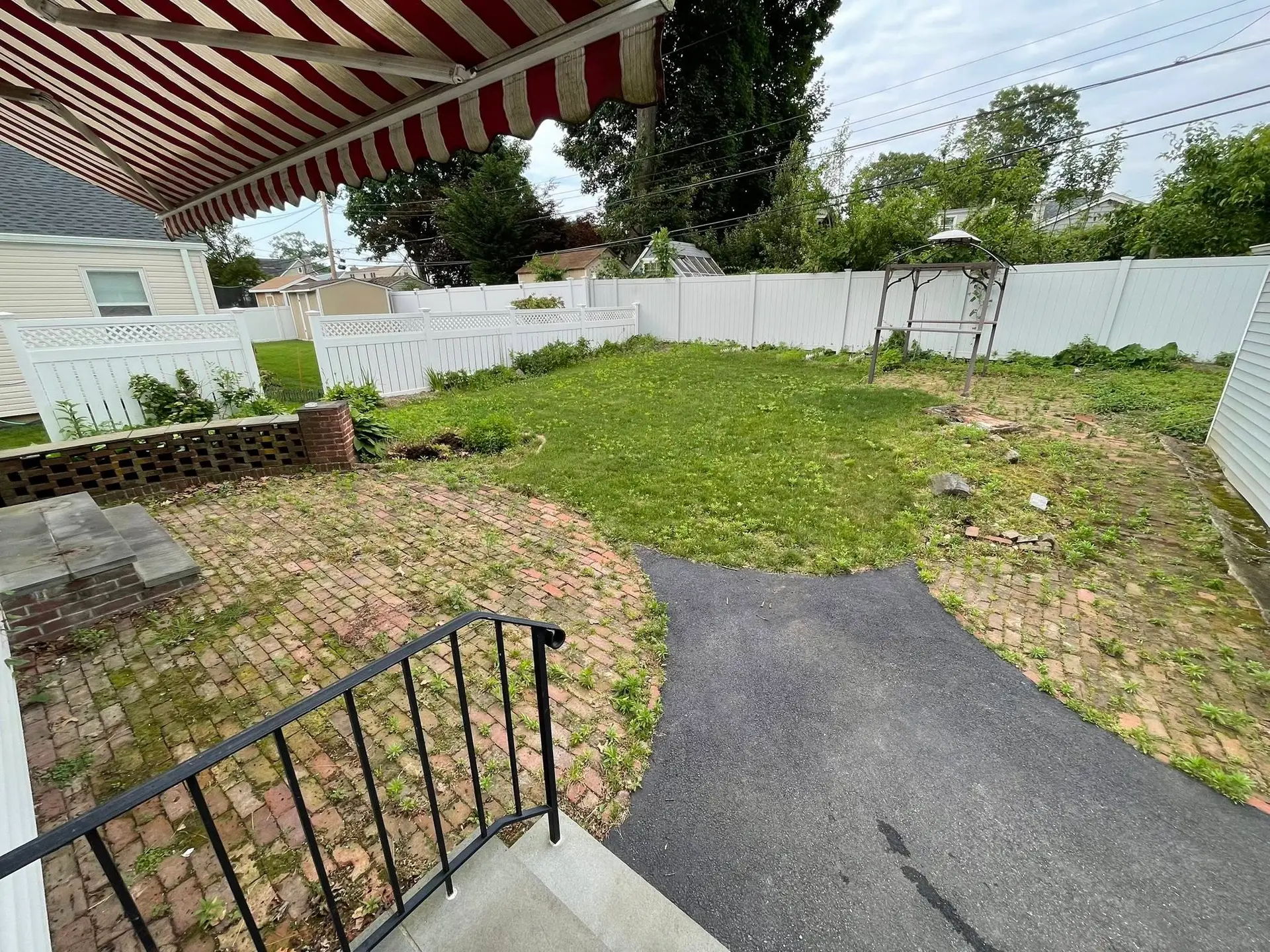Brick patio and masonry hardscape in an established backyard
